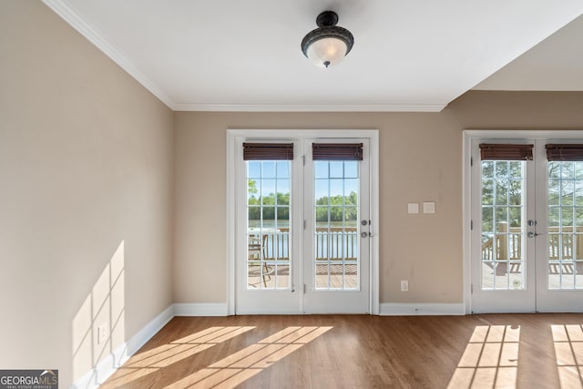 entryway with crown molding, french doors, and light hardwood / wood-style flooring