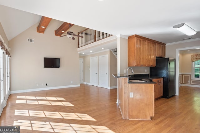 kitchen featuring light hardwood / wood-style flooring, ceiling fan, high vaulted ceiling, and black refrigerator