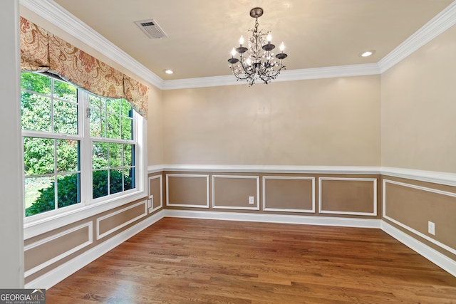 empty room with a notable chandelier, crown molding, dark hardwood / wood-style floors, and a healthy amount of sunlight