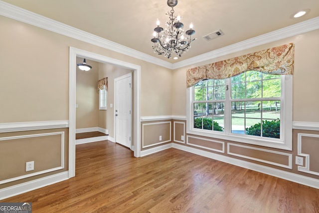 spare room featuring crown molding, a notable chandelier, and dark wood-type flooring