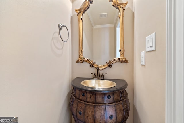 bathroom with ornamental molding and vanity with extensive cabinet space