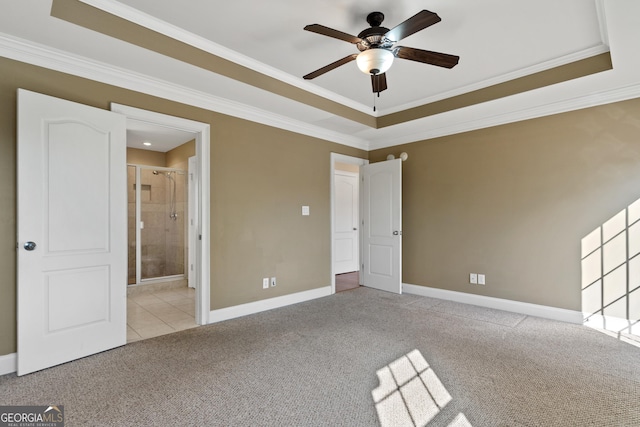 empty room with ceiling fan, crown molding, light colored carpet, and a raised ceiling