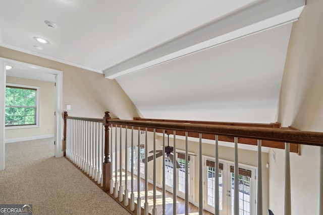 hallway with lofted ceiling with beams, french doors, and light carpet