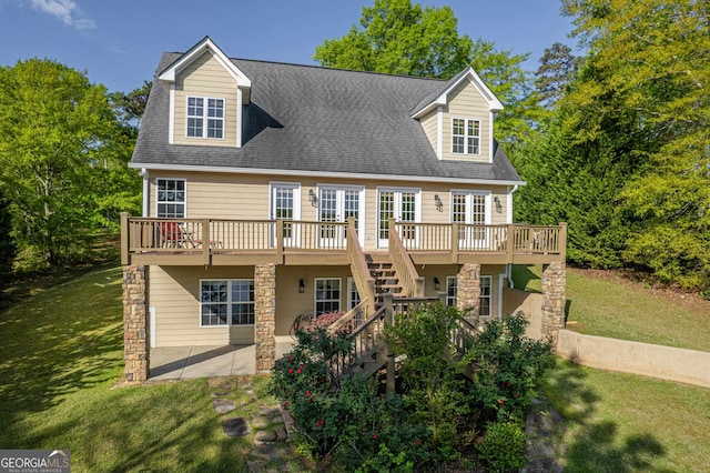 cape cod house with a wooden deck and a front lawn