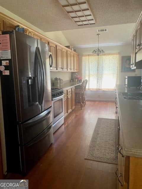 kitchen featuring dark hardwood / wood-style flooring, stainless steel fridge with ice dispenser, range, and sink