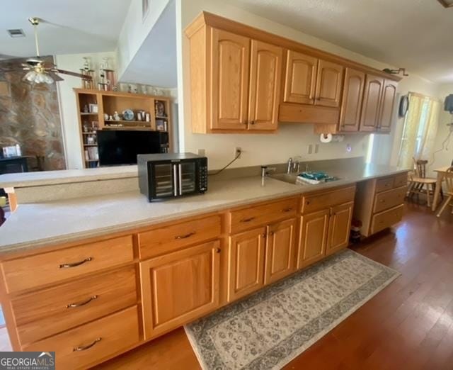 kitchen featuring ceiling fan, dark hardwood / wood-style floors, and sink