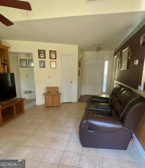 tiled living room featuring ceiling fan