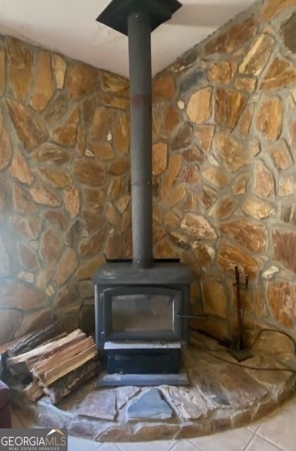 interior details featuring tile flooring and a wood stove