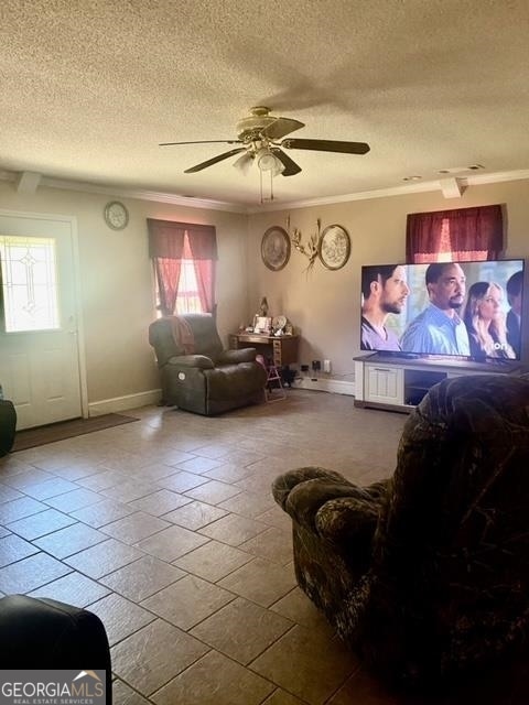 living room featuring plenty of natural light, ceiling fan, and ornamental molding