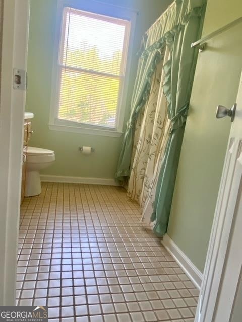 bathroom with toilet and tile floors