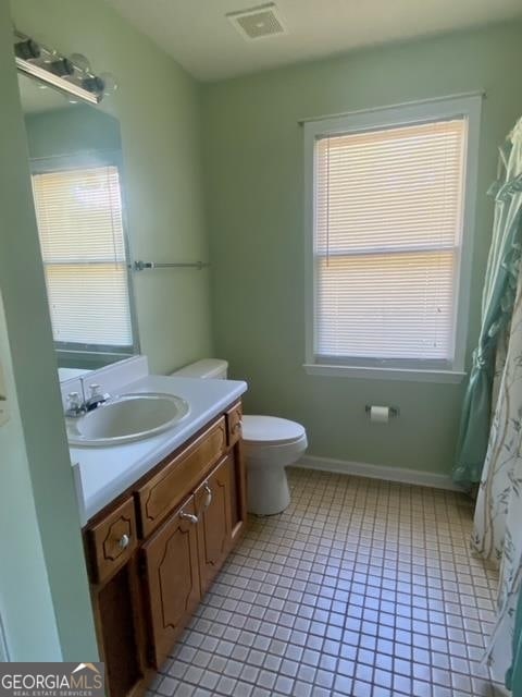 bathroom with tile floors, a healthy amount of sunlight, and large vanity