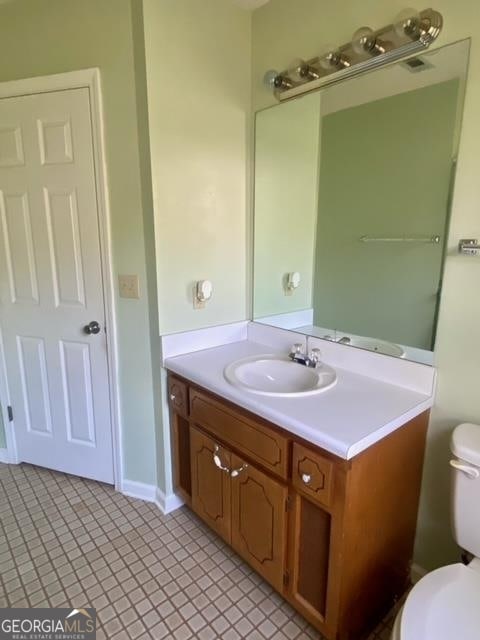 bathroom with tile flooring, oversized vanity, and toilet