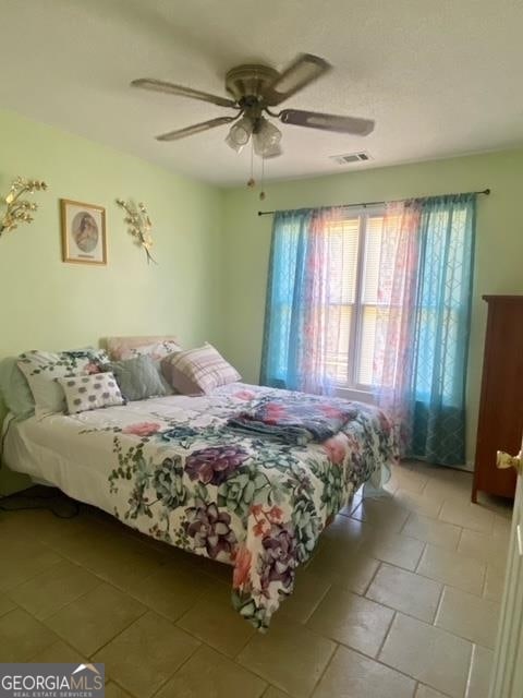 tiled bedroom with ceiling fan