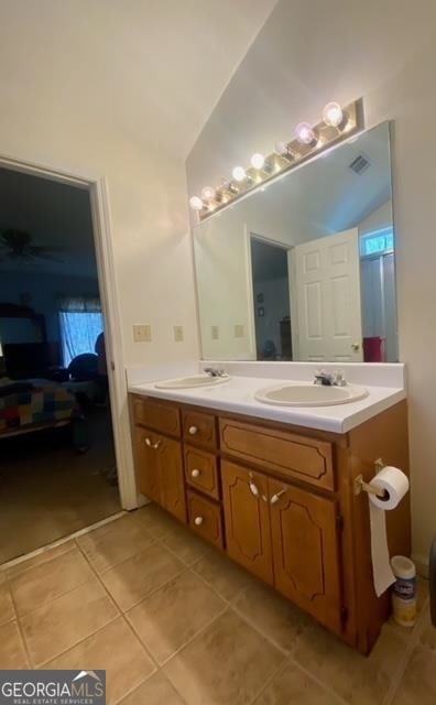 bathroom featuring lofted ceiling, tile flooring, and dual vanity