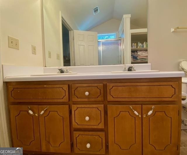 bathroom with lofted ceiling, dual sinks, toilet, and large vanity