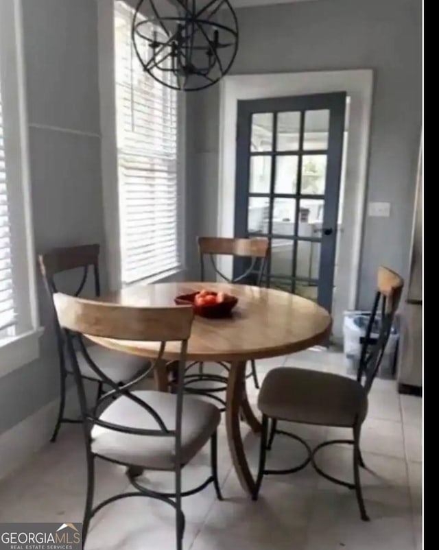 tiled dining room featuring a chandelier