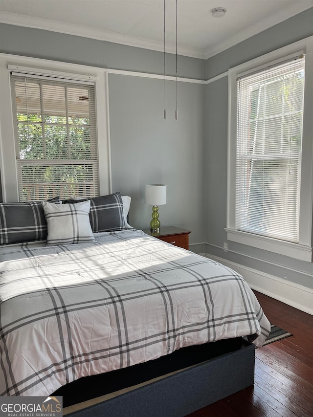 bedroom with multiple windows, ornamental molding, and hardwood / wood-style flooring