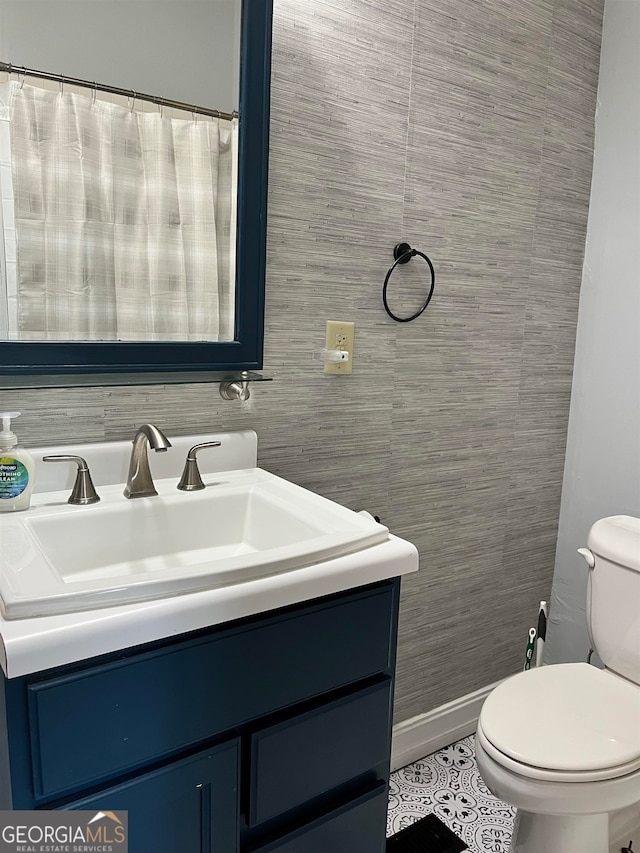 bathroom with toilet, vanity, tile walls, and tile floors