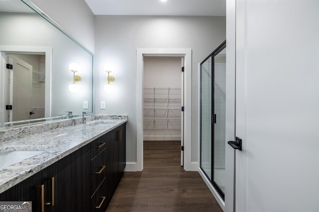 bathroom with a shower with door, vanity, and hardwood / wood-style floors