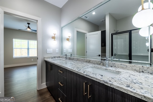 bathroom with wood-type flooring, vanity, a shower with door, and ceiling fan