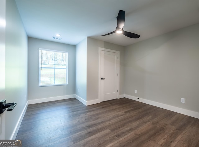 unfurnished room featuring ceiling fan and dark wood-type flooring