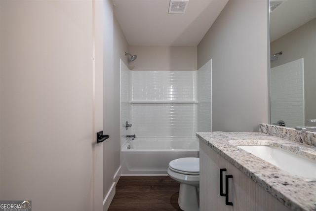 full bathroom with wood-type flooring, vanity, tub / shower combination, and toilet