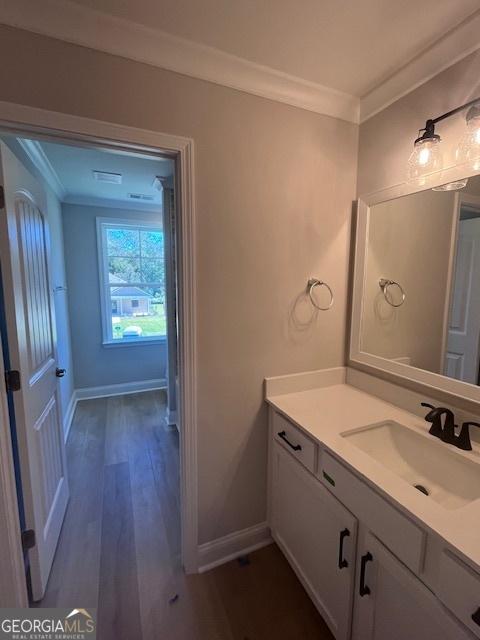 35 Fairwinds Unit 207, Waverly, GA 31565 - bathroom with vanity, baseboards, wood finished floors, visible vents, and ornamental molding