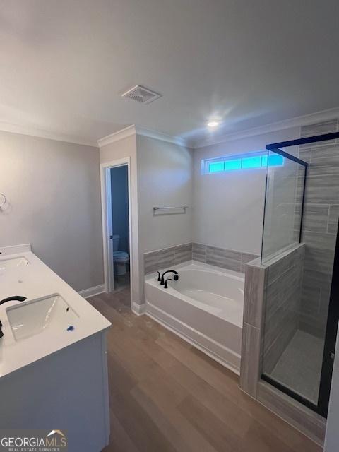35 Fairwinds Unit 207, Waverly, GA 31565 - full bath with a garden tub, crown molding, a shower stall, wood finished floors, and a sink