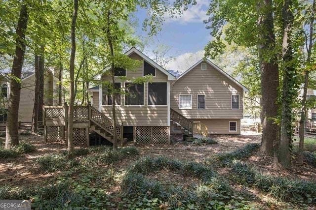 rear view of house featuring a deck and a sunroom