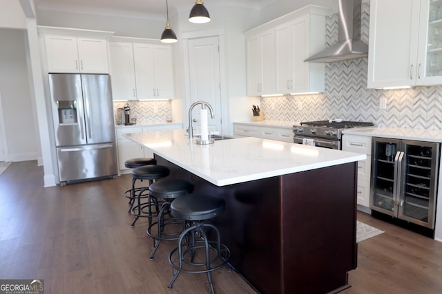 kitchen featuring stainless steel appliances, wine cooler, wall chimney exhaust hood, white cabinets, and pendant lighting