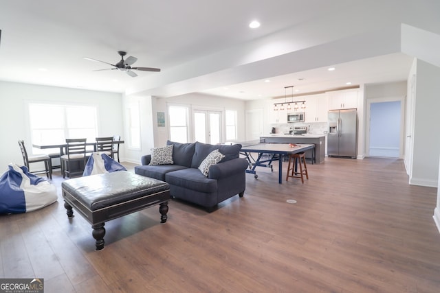 living room featuring ceiling fan and dark wood-type flooring