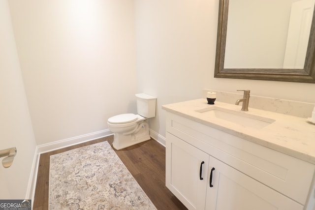 bathroom featuring oversized vanity, hardwood / wood-style flooring, and toilet