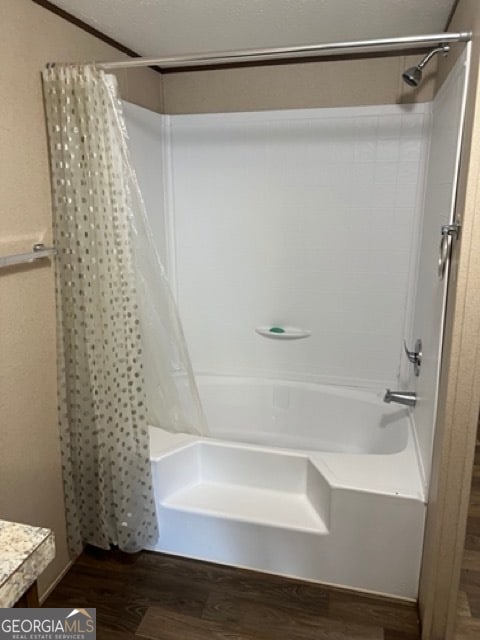 bathroom with shower / tub combo and hardwood / wood-style floors