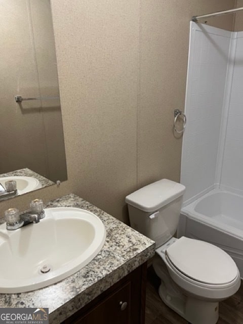 full bathroom featuring wood-type flooring, vanity, toilet, and tub / shower combination