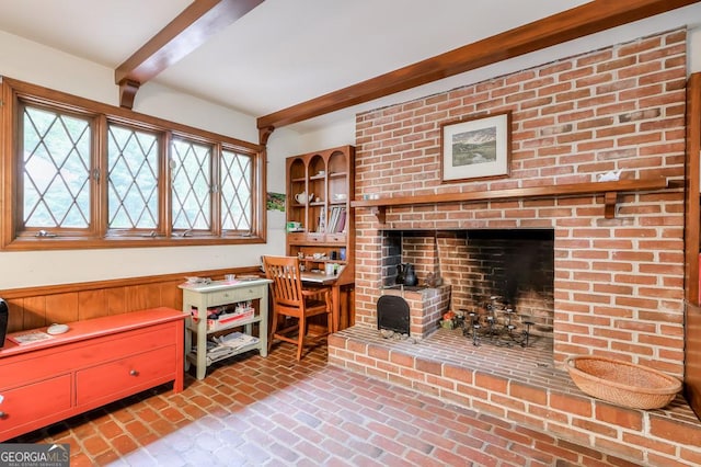 living room with wood walls, plenty of natural light, and beam ceiling