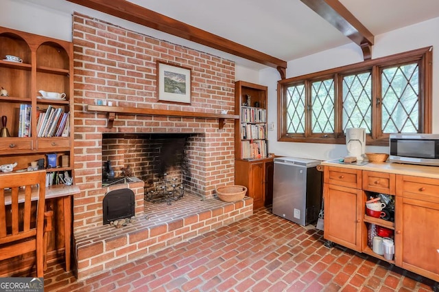 kitchen with beam ceiling, refrigerator, and a fireplace