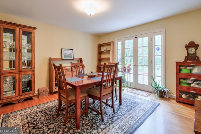 dining space with light wood-type flooring and french doors