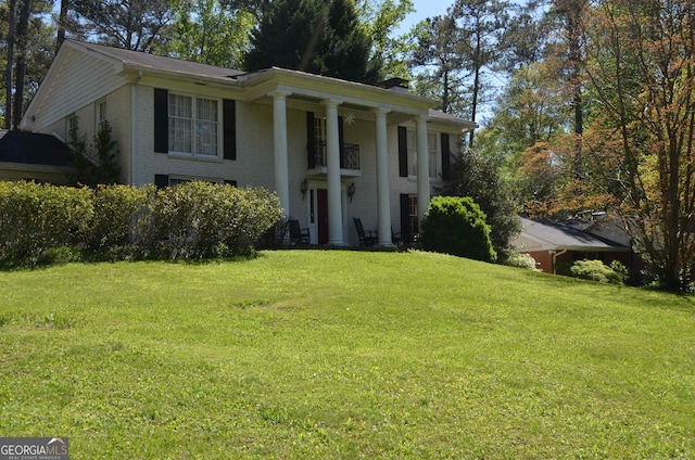 greek revival house featuring a front yard