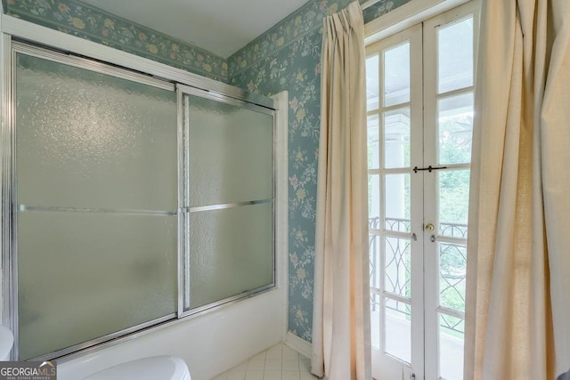 bathroom with toilet, bath / shower combo with glass door, and french doors