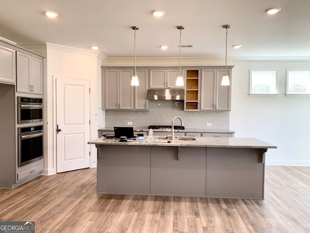 kitchen featuring gray cabinetry, light hardwood / wood-style flooring, and double oven