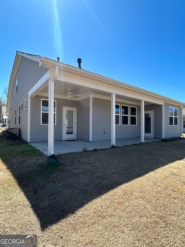 back of property with a patio and a lawn