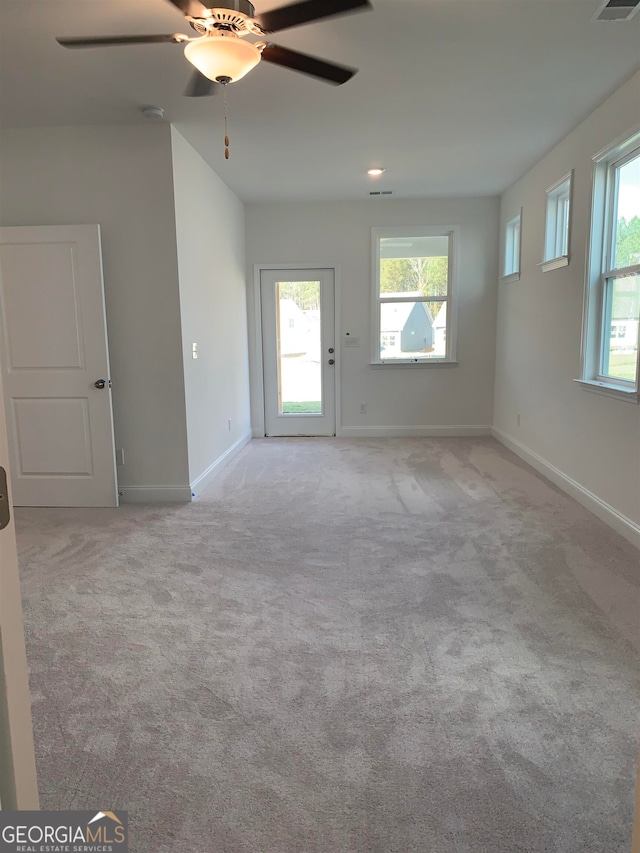 unfurnished room with light colored carpet and ceiling fan