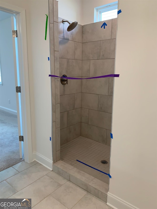 bathroom featuring a tile shower and tile flooring