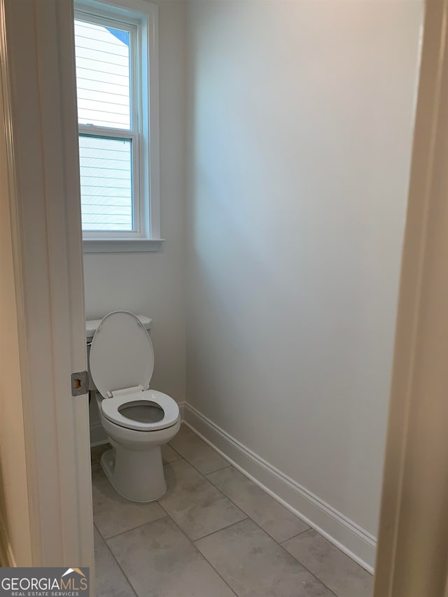 bathroom featuring toilet and tile floors