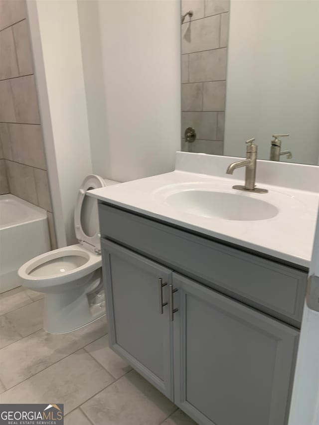 full bathroom with tile floors, tiled shower / bath, toilet, and large vanity