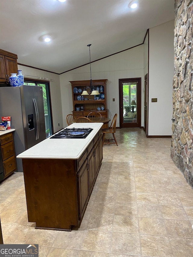 kitchen featuring lofted ceiling, hanging light fixtures, a kitchen island, stainless steel fridge with ice dispenser, and gas cooktop