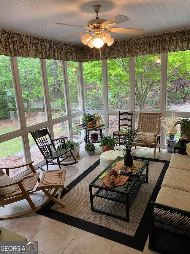 sunroom / solarium featuring ceiling fan, plenty of natural light, and wooden ceiling