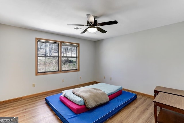 bedroom with light hardwood / wood-style floors and ceiling fan