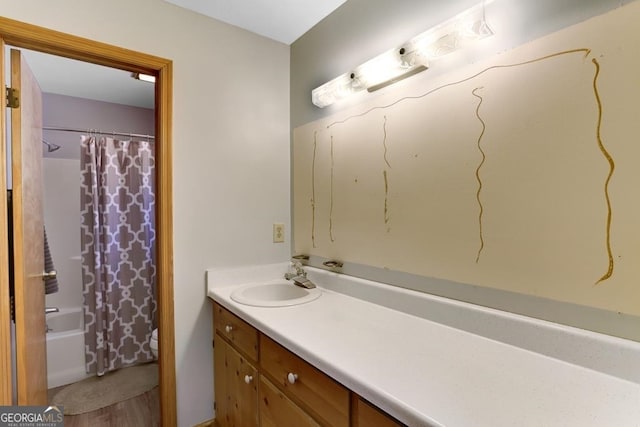 bathroom featuring shower / bath combination with curtain, vanity with extensive cabinet space, and hardwood / wood-style flooring