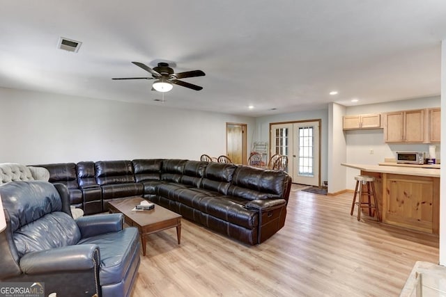 living room featuring french doors, light hardwood / wood-style flooring, and ceiling fan